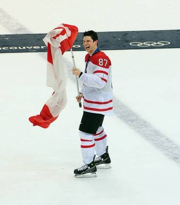 Canada s Sidney Crosby laughs as the flag he s carrying gets tangled after Canada beat the USA 3-2 in over time of the goldmedal men s ice hockey game at Canada Hockey Place in Vancouver, Canada, during the 2010 Winter Olympics on February 28, 2010.  OLY2010022825 o0 Jubel Freude Fahne, Nationalfahne, Objekte Sieg, Sieger, Olympiasieg, Olympiasieger,