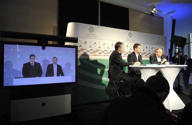 02.03.2010, Fussball : Pressekonferenz der deutschen Nationalmannschaft in München. Werbepräsentation vor den versammelten Journalisten: Live-Konferenzschaltung zur CEBIT nach Hannover zur Firma T-COM. rechts: v.li: Wolfgang Niersbach (DFB Generalsekretär), Teammanager Oliver Bierhoff, DFB Pressesprecher Harald Stenger (alle Deutschland). o0 Funktionär, Monitor, Monitore, Fernseher, Bildschirm, Bildschirme Objekte