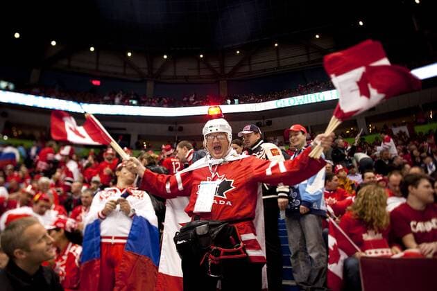 Feb. 24, 2010 - Vancouver, BC, Canada - Olympics Men s Hockey - Canadian fan wearing a helmet with a red blinking light hand out Canadian flags to other fans Quarterfinals Men s Hockey at the 2010 Winter Olympic on February 24, 2010 in Vancouver, BC. - ZUMAj89 o0 Objekte Fahne, Landesfahne Objekte