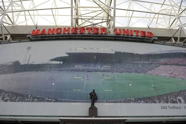 07.04.2010, Championsleague Viertelfinale Rückspiel, Am Stadion Old Trafford in Manchester (England) steht eine Statue von Sir Matt Busby (England). Dahinter ein Mega-Poster mit einer einer Zeitraffer-Darstellung des Stadion-Innenraumes.