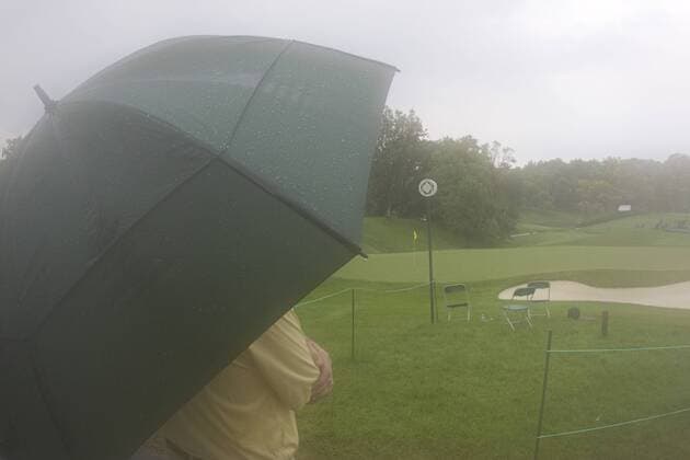 05 JUN 2010: A fan looks on to the 18th green waiting for the start of the Memorial Tournament s 3rd round. The tournament is under delay due to heavy rain and thunderstorms at Muirfield Village G.C. in Dublin, Ohio. Icon43910060566023 o0 Zuschauer Regenschirm Regen EDITORIAL USE ONLY