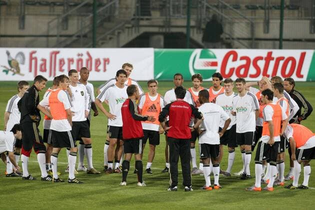 07.06.2010, Fußball-WM 2010, 1.Training der Deutschen Nationalmannschaft im Lucas Moripe Stadium in Atteridgeville Pretoria. Bundestrainer Joachim Löw (Deutschland, Mitte) und Co-Trainer Hans-Dieter Flick (Deutschland, li. daneben) halten eine Ansprache vor dem Team. PUBLICATIONxONLYxINxGERxSUIxAUT o0 Trainer Nationaltrainer Totale Werbebande Bande Werbung Sponsor Wirtschaft Haßeröder Castrol