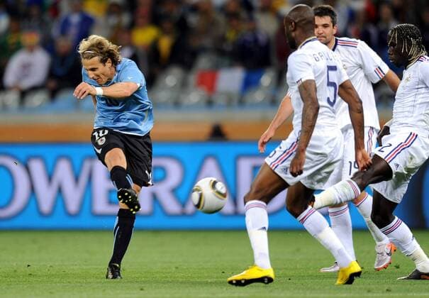 Diego Forlan (L) of Uruguay passes the ball during a Group match of the 2010 FIFA World Cup against France in Cape Town, on June 11, 2010. - France (white) vs Uruguay - 
