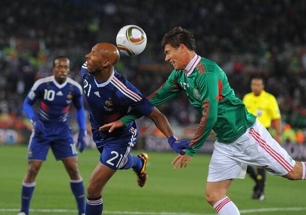 Nicolas Anelka of France tussles with Hector Moreno of Mexico --- FIFA World Cup 2010 - France (blue) vs Mexico (green) 0:2 --- EDITORIAL USE ONLY. No use with unauthorised audio, video, data, fixture lists, club league logos or live services. Online in-match use limited to 120 images, no video emulation. No use in betting, games or single club league player publications.