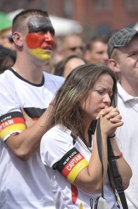 Deutsche Fußballfans verfolgen ein Vorrundenspiel Deutschlands anlässlich der Fußball-Weltmeisterschaft 2010 in der Kulturbrauerei in Berlin-Prenzlauer Berg Fußball WM - Enttäuschtes Fanpaar mit Kapitänsbinden von Captain Morgan Rum o0 Gesichtsbemalung, Bemalung, bemalt Mann Frau Paar Wirtschaft Werbung