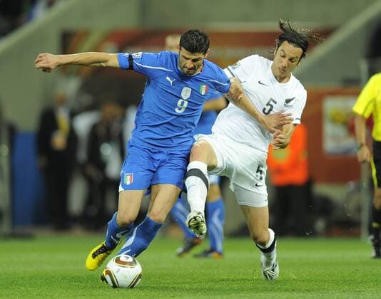 Vincenzo Iaquinta of Italy challenged by Ivan Vicelich of New Zealand FIFA World Cup 2010 Group F Italy (ITA blue) vs New Zealand (NZL white) 20th June, 2010 EDITORIAL USE ONLY. No use with unauthorised audio, video, data, fixture lists, club league logos or live services. Online in-match use limited to 120 images, no video emulation. No use in betting, games or single club league player publications.