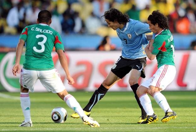 Edinson Cavani (C) of Uruguay breaks through during the 2010 World Cup Group A soccer match against Mexico at Royal Bafokeng Stadium in Rustenburg - 