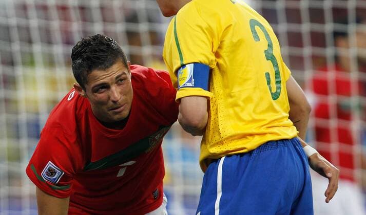 DURBAN, June 25, 2010 Brazil s Lucio (R) helps Portugal s Cristiano Ronaldo during the Group G last round match at 2010 FIFA World Cup, at Moses Mabhida stadium in Durban, on June 25, 2010. 