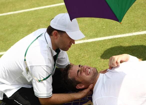 American John Isner gets physio treament between changeovers  LON2010062507 o0 USA Verletzung Erschöpfung Arzt Behandlung Nacken Nackenverletzung Aufmacher Schmerz