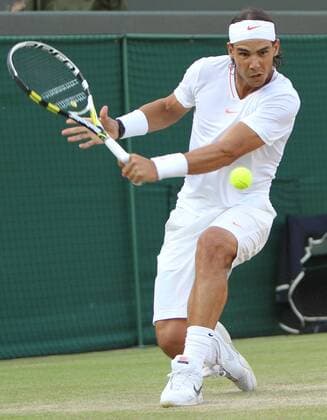 Sapain s Rafael Nadal plays a backhand in his match on the seventh day of the Wimbledon championships in Wimbledon on June 28, 2010.  LON2010062841