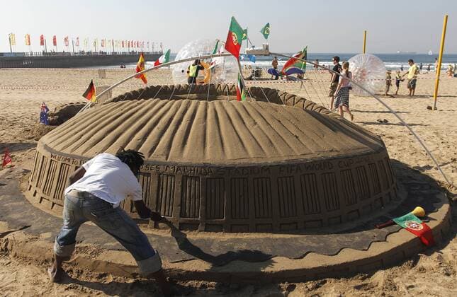 Fußballverückte Fans bauen aus Sand das Moses Mabhida Stadium von Durban nach - x(134)xRodolfoxBuhrerx xLaxImagemx  (810) o0 kurios Komk Fußballfieber Strand Sandburg RSA South Africa Aufmacher