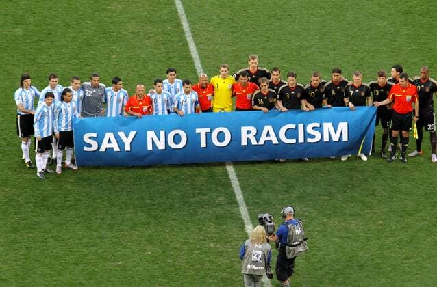 Players of Argentina and Germany pose together with a banner which reads say no to racism prior to their 2010 World Cup quarterfinal soccer match at Green Point stadium in Cape Town on July 3, 2010. From left: Martin Demichelis, Lionel Messi, Gonzalo Higuain, Carlos Tevez, Nicolas Otamendi, Sergio Romero, Angel di Maria, Linesman Bakhadyr KOCHKAROV (KGZ), Maxi Rodriguez, Nicolas Burdisso, Javier Mascherano, 4. Official Jerome DAMON (RSA), Manuel Neuer, Referee Ravshan IRMATOV (UZB), Per Mertesacker, Philipp Lahm, Miroslav Klose, Arne Friedrich, Lukas Podolski, Sami Khedira, Bastian Schweinsteiger, Thomas Müller, Mesut Özil, Linesman Rafael ILYASOV (UZB), Jerome Boateng 