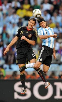 Miroslav Klose (L) of Germany heads the ball with Martin Demichelis of Argentina during their 2010 World Cup quarterfinal soccer match at Green Point stadium in Cape Town on July 3, 2010.  o0 Kopfballduell