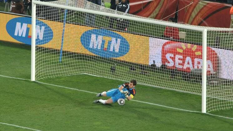 Spain s goalkeeper Iker Casillas saves the ball during the 2010 World Cup quarterfinal soccer match between Paraguay and Spain . 