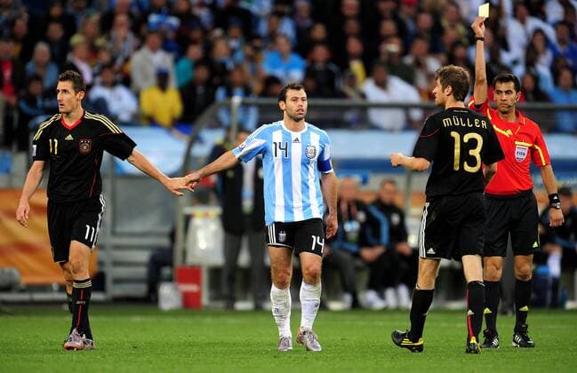 Viertelfinale, Argentinien - Deutschland im Green-Point-Stadion Kapstadt, Thomas Müller (2.v.re, Deutschland) sieht die gelbe Karte - Er ist aufgrund seiner zweiten gelben Karte für das Halbfinale gesperrt- Schiedsrichter Ravshan Irmatov (re, Usbekistan), li: Miroslav Klose (Deutschland) und Javier Mascherano (Argentinien) -  Sperre Gelbsperre gesperrt