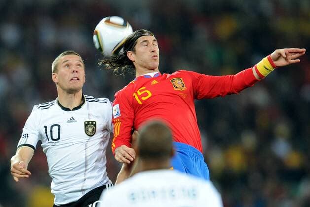 Germany s Lukas Podolski (L) vies with Spain s Sergio Ramos during the 2010 World Cup semifinal match in Durban July 7, 2010. 