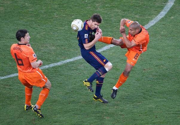 Football - 2010 FIFA World Cup - Final - Spain vs. Netherlands Nigel de Jong (R) of the Netherlands kicks Xabi Alonso (C) of Spain in the chest earning himself a yellow card next to Mark van Bommel (L) of Netherlands at Soccer City Stadium, Johannesburg  o0 Foulspiel, gefoult, Härte, Kampf, Tritt brutal Brutalität