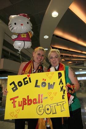 12.07.2010, Frankfurt Main - Danke Jogi Löw - Fußball-Gott -Silvia Horn und Diana Segref kommen aus dem Sauerland und warten seit 2 Uhr auf dem Frankfurter Flughafen auf die Rückkehr der DFB-Elf von der WM 2010. o0 weiblich Frau Objekte Plakat Fanplakat Transparent Schriftzug Joachim Trainer Nationaltrainer