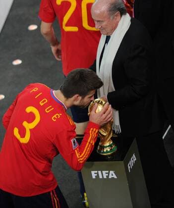JOHANNESBURG, July 11, 2010 -- Spain s Gerard Pique (L) kisses the trophy before the awarding ceremony of the World Cup final with FIFA president Joseph S. Blatter (SUI) at Soccer City stadium in Johannesburg, July 11, 2010. Spain won the final 1-0. ---  o0 Sepp Funktionär Objekte Pokal Trophäe Kuss küssen