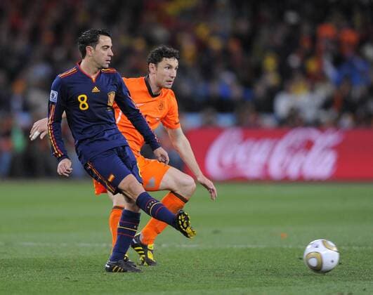 Xavi Hernandez of Spain and Mark Van Bommel of Netherlands FIFA World Cup 2010 Final Netherlands (orange) vs Spain (blue) 11th July, 2010 EDITORIAL USE ONLY. No use with unauthorised audio, video, data, fixture lists, club league logos or live services. Online in-match use limited to 120 images, no video emulation. No use in betting, games or single club league player publications.