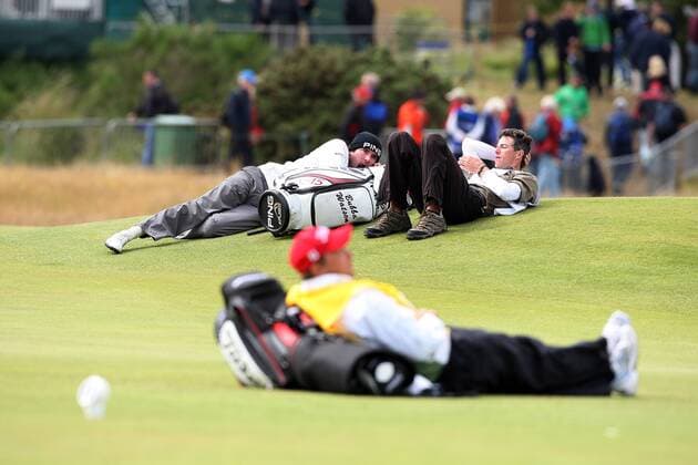 Golf - The British Open - St Andrews Due to high winds causing the balls to oscillate play has been suspended during the second day of the open. Picture is Bubba Watson and his caddie sitting on the Seventeenth green. 