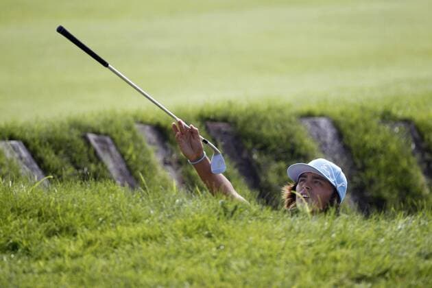 Rickie Fowler hands his caddie a club as he stands in a bunker on the 11th hole during the first round of the 92nd PGA Championship at Whistling Straits in Kohler, Wisconsin on August 12, 2010.  BKX2010081224 o0 Golfschläger Objekte Schläger