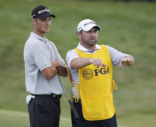 Martin Kaymer of Germany (L) talks to his caddie Craig Connelly on the 18th green during the playoff for the 92nd PGA Championship at Whistling Straits in Kohler, Wisconsin on August 15, 2010. Kaymer won a three-hole playoff by one stroke to win the tournament after finishing regulation play with a 11-under-par 277.  BKX2010081550