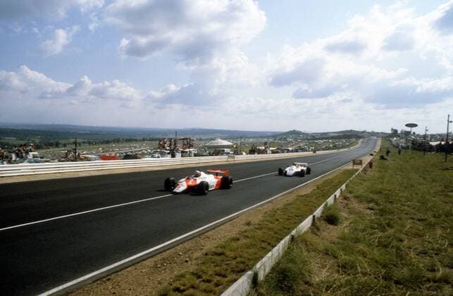 Niki Lauda (Österreich McLaren Ford) vor Derek Daly (Irland Theodore Ford) auf der langen Geraden von Kyalami  o0 Sportstätte Totale Rennstrecke Rennkurs Strecke Kurs Circuit Gerade, Startgerade, Zielgerade