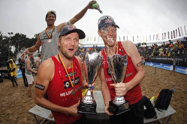 Beachvolleyball, Deutsche smart Beachvolleyballmeisterschaft Timmendorfer Strand 2010, Gewinner des Männer Finale - Julius Brink (L) und Jonas Reckermann (beide GER), dahinter giesst Eric Koreng (GER) Champagner auf die Sieger, xHOCHxZWEIx xThomasxVictorx