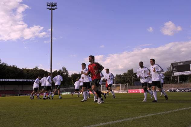 05.09.2010, Fussball DFB Training in Köln im Südstadion, Fitnesstrainer Yan Benjamin Kugel (Deutschland, Mitte) und die Spieler laufen sich warm. o0 totale