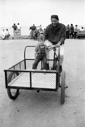 Torwart Petar Radi Radenkovic (1860) fährt mit seiner Tochter Naols mit einem Fahrrad die Promenade von Budva entlang Fußball Herren Saison 1966 1967, TSV 1860 München, Urlaub, Freizeit, Einzelbild Budva
