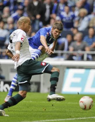 25.09.2010, Fussball-Bundesliga, FC Schalke 04 (blau) - Borussia Moenchengladbach Gladbach (weiss) 2:2 -- Bamba ANDERSON (L) verteidigt einen Schuss von Klaas-Jan HUNTELAAR 25.09.2010 german Bundesliga, Schalke 04 vs Borussia Moenchengladbach 2:2 -- ANDERSON defends against Klaas-Jan HUNTELAAR celebrates his goal o0 Gelsenkirchen
