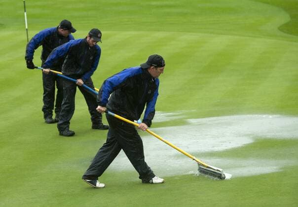 Golf - Ryder Cup 2010 - Day 1 Fourballs: Green Keepers attempt to clear standing water from the 3rd green at Celtic Manor, Newport  o0 Helfer Regen Platzpflege Totale Greenkeeping Greenkeeper Platzverhältnisse Sportstätte Grün