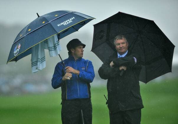 Golf - Ryder Cup 2010 - Day 1 Fourballs: Lee Westwood (England) of Europe talks to a match official as the rain comes down at Celtic Manor, Newport  o0 Regen Regenschirm