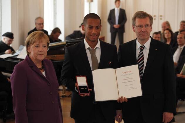 Verleihung des Silbernen Lorbeerblattes an die Spieler der Nationalmannschaft der Fußball-WM 2010 Bundeskanzlerin Angela Merkel (li.) und Bundespräsident Christian Wulff (re., beide CDU beide Deutschland) verleihen Dennis Aogo das Silberne Lorbeerblatt o0 Silbernes people Politik Urkunde Objekt Freude privat