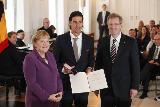Verleihung des Silbernen Lorbeerblattes an die Spieler der Nationalmannschaft der Fußball-WM 2010 Bundeskanzlerin Angela Merkel (li.) und Bundespräsident Christian Wulff (re., beide CDU beide Deutschland) verleihen Sami Khedira das Silberne Lorbeerblatt o0 Silbernes people Politik Urkunde Objekt Freude privat