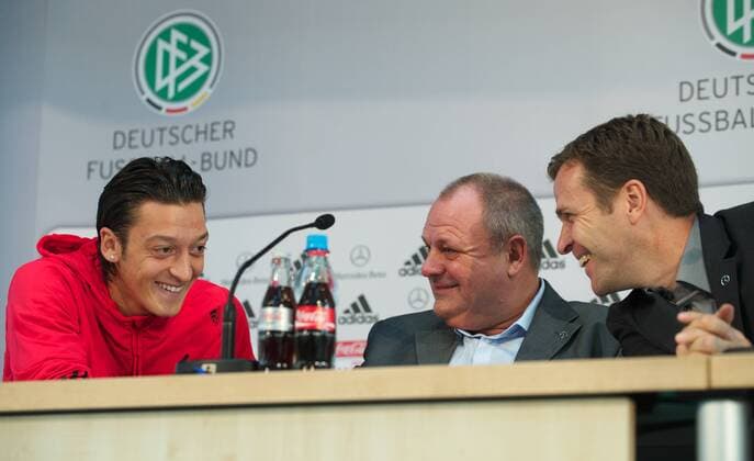 Berlin 06.10.2010 - DFB Pressekonferenz - Mesut Özil (L) übersetzt die Frage eines Türkischen Journalisten für Teammanager Oliver Bierhoff (R), da der Simultan-Dolmetscher aus technischen Gruenden ausgefallen ist Nationalmannschafts Pressesprecher Harald Stenger (GER) lacht mit
