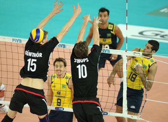 Amaral Dante Guimaraes (R) of Brazil spikes the ball over the German block by Gunthor Max (L) and Schops Marcus (C) Brazil (yellow) vs. Germany (black) xMarcoxMegax  ActionPlus11101160 Content restricted for UK based newspaper