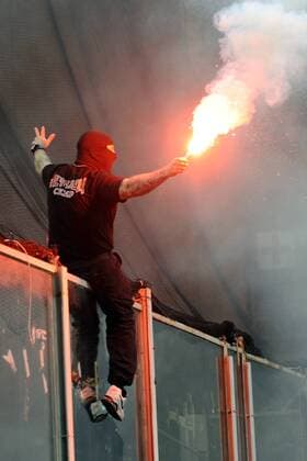 Spielabbruch nach Fanausschreitungen im EM Qualifikationsspiel Italien vs Serbien: Der serbische Hooligan Ivan Bogdanov (Ultra Boys Roter Stern Belgrad, li.) durchtrennt das Sicherheitsnetz und initiiert mit dem Werfen von Feuerwerkskörpern die Randale im serbischen Fanblock 