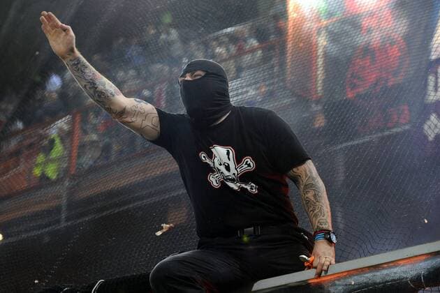 Spielabbruch nach Fanausschreitungen im EM Qualifikationsspiel Italien vs Serbien: Der serbische Hooligan Ivan Bogdanov (Ultra Boys Roter Stern Belgrad, li.) durchtrennt das Sicherheitsnetz und initiiert die Randale im serbischen Fanblock. Mit dem römischen Gruß seine rechtsextreme Gesinnung. 
