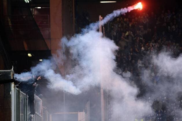 Spielabbruch nach Fanausschreitungen im EM Qualifikationsspiel Italien vs Serbien: Der serbische Hooligan Ivan Bogdanov (Ultra Boys Roter Stern Belgrad, li.) durchtrennt das Sicherheitsnetz und initiiert mit dem Werfen von Feuerwerkskörpern die Randale im serbischen Fanblock 