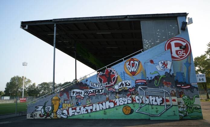 Fußball, Stadiongeschichte Fortuna Düsseldorf Gemälde an der Haupttribüne des Paul Janes Stadion am Flinger Broich in Düsseldorf, Ausweichspielort von Fortuna Düsseldorf o0 Totale Tribüne Kunst Graffiti