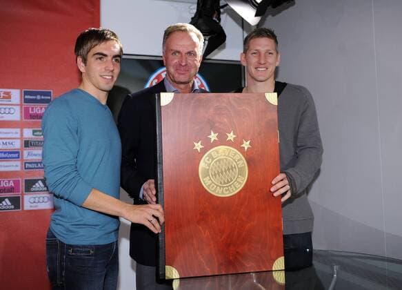 Fussball 1. Bundesliga: Saison 2010 2011, 10.11.2010 Der FC Bayern Muenchen praesentiert die 30kg schwere Vereinschronik (v.li) Philipp Lahm, Vorstandsvorsitzender Karl Heinz Rummenigge, Bastian Schweinsteiger (FC Bayern Muenchen) 