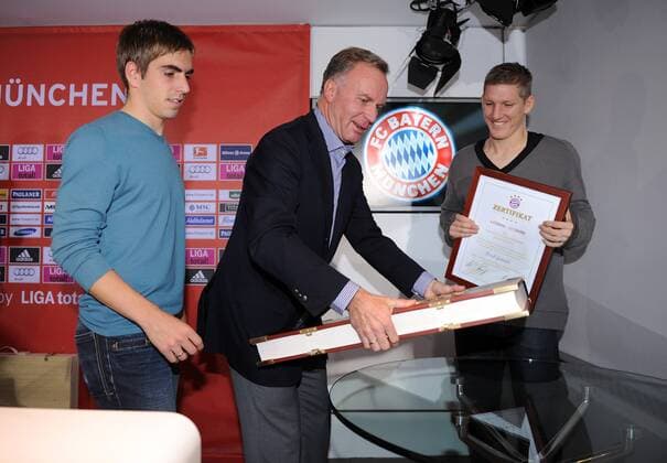 Fussball 1. Bundesliga: Saison 2010 2011, 10.11.2010 Der FC Bayern Muenchen praesentiert die 30kg schwere Vereinschronik (v.li) Philipp Lahm, Vorstandsvorsitzender Karl Heinz Rummenigge, Bastian Schweinsteiger (FC Bayern Muenchen) 