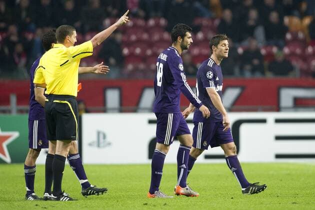 Schiedsrichter Craig THOMSON (SCO, 2.v.li.) zeigt Xabi ALONSO (Real, re.) wegen Zeitspiel die Gelb - Rote Karte, Alvaro ARBELOA (li.) und Raul ALBIOL (beide Real) diskutieren mit dem Schiedsrichter, Fussball Champions League, Vorrunde 5. Spieltag, AFC Ajax Amsterdam - Real Madrid CF 0:4
