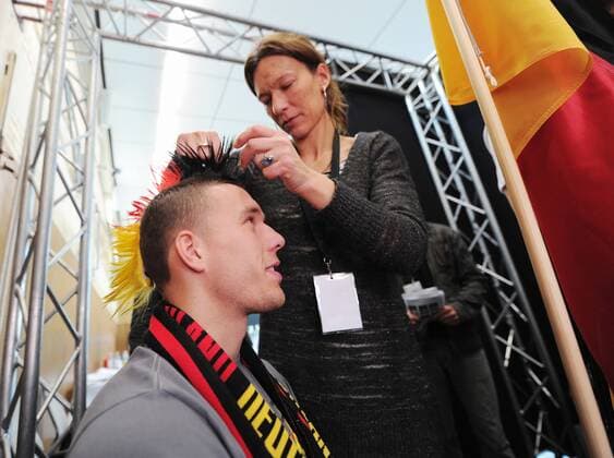 Lukas PODOKLSKI mit kuenstlicher Frisur in der Maske --- Werbedreh für den DFB-Generalsponsor Mercedes-Benz mit der deutschen Männernationalmannschaft in Kaiserau o0 kurios Komik Perücke Frisur Iro Landesfarben Fan