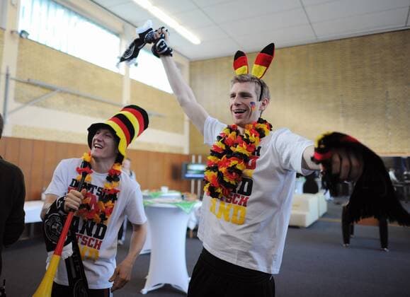Bastian SCHWEINSTEIGER und Per MERTESACKER in Fan-Outfit --- Werbedreh für den DFB-Generalsponsor Mercedes-Benz mit der deutschen Männernationalmannschaft in Kaiserau o0 kurios Komik Landesfarben Fan Jubel Freude