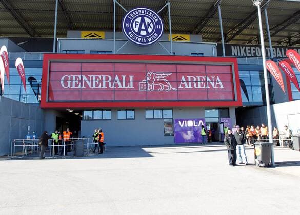 Bild zeigt Fans beim Eingang der Generali Arena, Heimspielstätte des FK Austria Wien  o0 Logo, Emblem, Vereinslogo, Vereinsemblem Schriftzug Sponsor, Werbepartner, Werbung, Wirtschaft