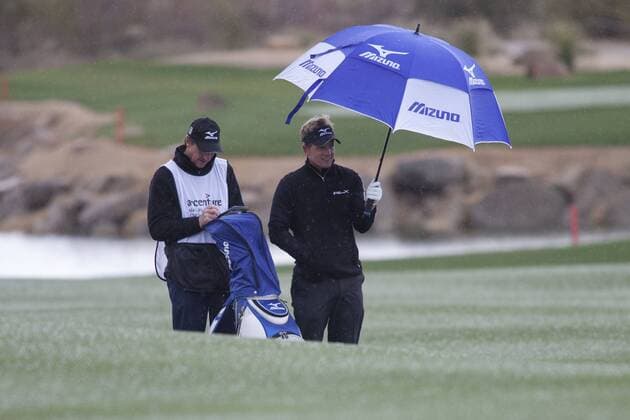 Marana, Arizona, LUKE DONALD (England, R) and caddy hunker down underneath an umbrella during a hail flurry while competing in the final match at the Accenture Match Play Championship - - ZUMAhk1