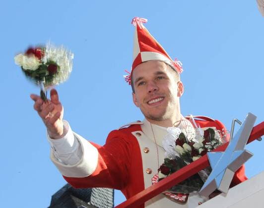 Lukas Podolski (1. FC Köln) nimmt auf einem Festwagen der Roten Funken am Rosenmontagszug teil